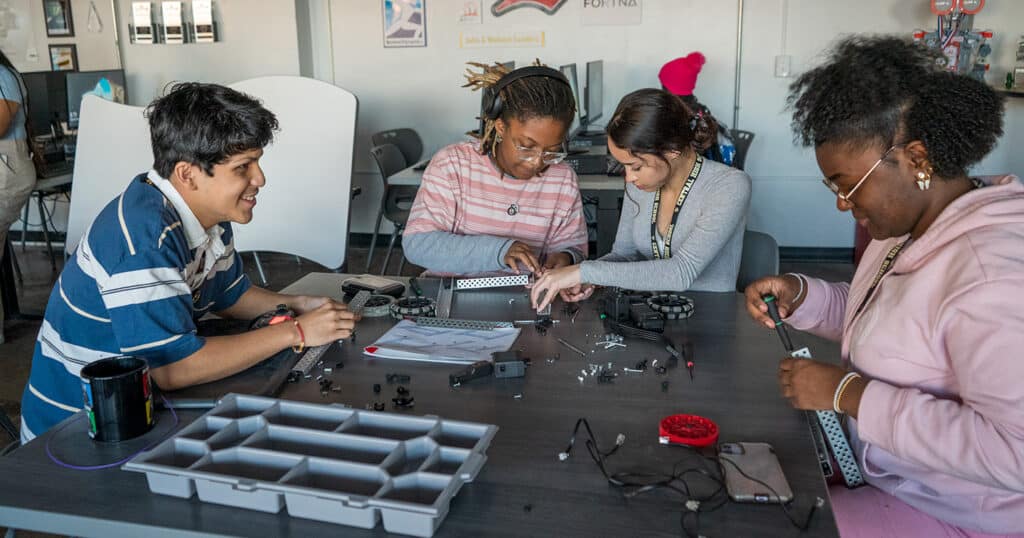 Students work on robotics components in a STEM classroom